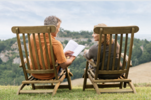 Couple-on-lawn-chairs-he-is-sharing-a-book