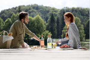 a-couple-picinicing-with-a-forest-in-the-distant-background